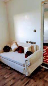 biała kanapa z poduszkami w pokoju w obiekcie Résidence London w mieście Al-Ujun