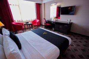 Arman Hotel Juffair Mall في المنامة: غرفه فندقيه بسرير ومكتب وكراسي