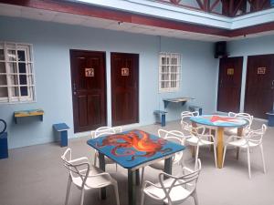 two tables and chairs in a room with blue walls at Surfari Bocas in Bocas Town