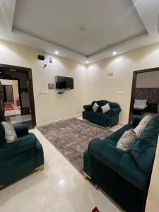 een woonkamer met 2 banken en een flatscreen-tv bij فندق الفيصلية in Hajlah