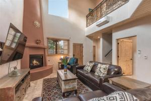 a living room with a leather couch and a fireplace at Linda - Walk to The Plaza in Santa Fe