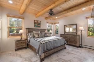 a bedroom with a bed and two dressers and windows at Linda - Walk to The Plaza in Santa Fe