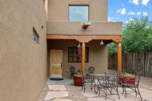 a patio with a table and chairs in front of a house at Linda - Walk to The Plaza in Santa Fe