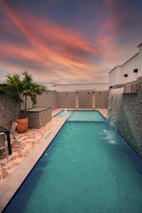 a swimming pool with a sunset in the background at Hotel Buddha Mystic By Del Toro in Doradal