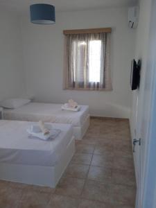 a white room with two beds and a window at Iliachtida apartments in Philotium