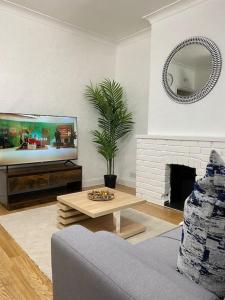 a living room with a tv and a couch and a table at House in Medway in Gillingham