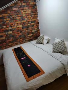a bed in a room with a brick wall at RANGOON RESIDENCES + in George Town