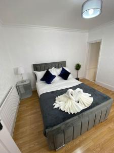 a bedroom with a large bed with blue and white pillows at House in Medway in Gillingham