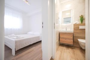 1 dormitorio con cama, lavabo y aseo en New Family Apartments with private parking near Zadar en Murvica