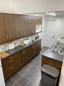 una cucina con armadi in legno e piano cottura. di House in Medway a Gillingham
