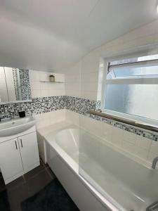 a white bathroom with a tub and a sink at House in Medway in Gillingham