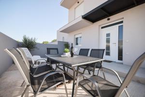 y un patio con mesa de comedor y sillas. en New Family Apartments with private parking near Zadar en Murvica