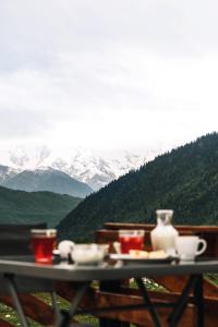 - une table avec de la nourriture et des boissons au sommet d'une montagne dans l'établissement Panorama Ushba, à Mestia