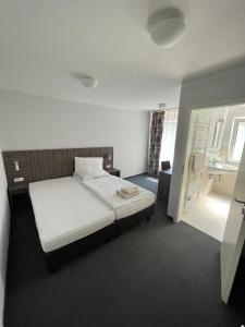 1 dormitorio con cama blanca y lavamanos en Altes Backhaus, en Herzogenaurach