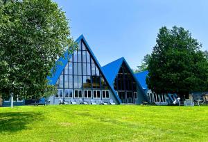 a large building on a grass field with trees at NewVida Preserve in Wilmington