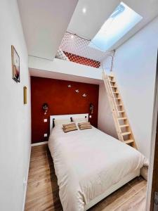 - une chambre avec un lit blanc et une échelle dans l'établissement Escapade Berckoise, Berck Plage, à Berck-sur-Mer