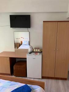 a kitchen with a small refrigerator and a desk with a television at Summer SZ Guest House in Sozopol