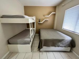 Un dormitorio con dos literas y una ventana. en Chamonix, en Itapema