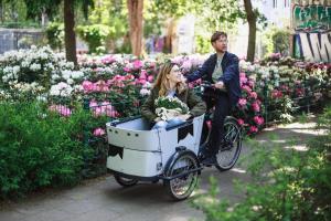 Ein Mann und eine Frau, die mit einem Korb Fahrrad fährt. in der Unterkunft The Circus Apartments in Berlin