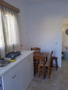 una cucina e una sala da pranzo con lavandino e tavolo di Iliachtida apartments a Philotium