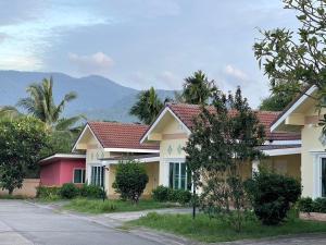 eine Reihe von Häusern mit Bergen im Hintergrund in der Unterkunft ธนวรรณรีสอร์ท - Thanawan Resort in Ban Phra Trong