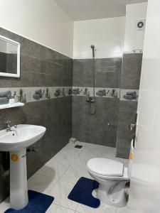 ein Bad mit einem WC, einem Waschbecken und einer Dusche in der Unterkunft إقامة الامل in Beni Mellal