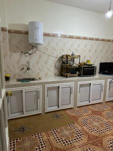 una cucina con armadi bianchi e piano di lavoro di إقامة الامل a Beni Mellal