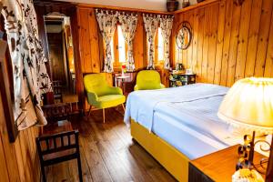 ein Schlafzimmer mit einem Bett, zwei Stühlen und einer Lampe in der Unterkunft Lavanda Restaurant with Rooms in Kovachevitsa