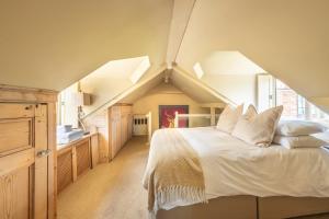 a bedroom with a bed with white sheets and pillows at Wiveton Bell in Blakeney +30 photos