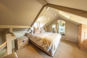 a bedroom with a large bed in an attic at Wiveton Bell in Blakeney