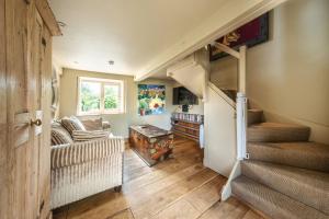 a living room with a staircase and a couch and a table at Wiveton Bell in Blakeney