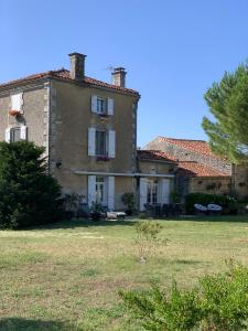 uma grande casa de tijolos com um quintal em frente em NO5 Chambre D'hotes em Courcôme