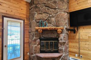 a stone fireplace in a room with a tv at Buffalo Beauty in Granby
