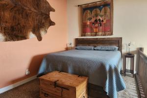 1 dormitorio con 1 cama y una pintura en la pared en Buffalo Beauty, en Granby