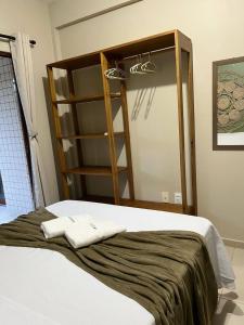 a bedroom with a bed and a book shelf at Apartamento de Frente para o Mar na praia da Taiba Ceará in Taíba
