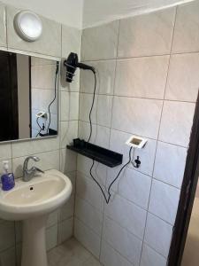 a bathroom with a sink and a blow dryer on the wall at Ghanem building 15 in Bethlehem