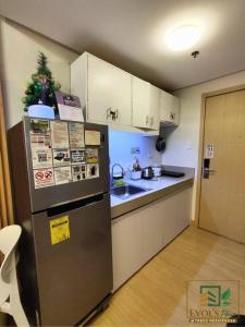 une petite cuisine avec un réfrigérateur et un évier dans l'établissement Trees Residences Staycation Evol's Place, à Manille