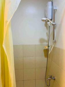 La salle de bains est pourvue d'une douche avec rideau de douche. dans l'établissement Trees Residences Staycation Evol's Place, à Manille