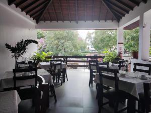 a restaurant with tables and chairs and a large window at Hotel Viajante in Tarrafal