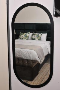 a bedroom with a bed in a mirror at Square Connexions Guest House in Gaborone