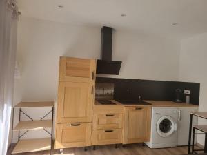 a kitchen with a stove top oven next to a washing machine at STUDIO A 2 MN DE L A75 in Usclas-lʼHérault
