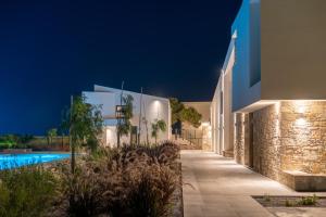 a villa with a swimming pool at night at Itida Suites in Sitia