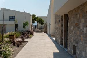 a walkway between two buildings with plants at Itida Suites in Sitia