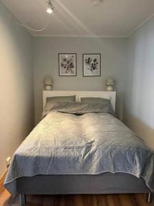 a bed in a bedroom with two pictures on the wall at Cozy ground floor apartment in Tromsø +13 photos