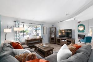a living room with a couch and a tv at Oraibi Oasis-A Phoenix Paradise- Pool, Spa, Putting Green, EV Charger in Phoenix