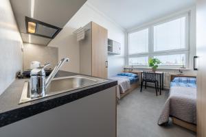 uma cozinha com um lavatório e um quarto com uma cama em Penzion BIG HOUSE em Praga