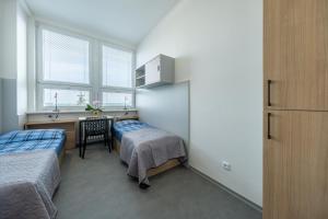 1 dormitorio con 2 camas, escritorio y mesa en Penzion BIG HOUSE en Praga