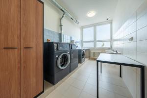 eine Waschküche mit Waschmaschine und Trockner in der Unterkunft Penzion BIG HOUSE in Prag