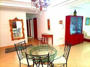 une salle à manger avec une table et des chaises en verre dans l'établissement appartement de vacances, à Kenitra