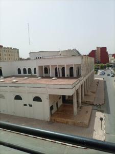un bâtiment blanc avec un toit rouge dans une rue dans l'établissement appartement de vacances, à Kenitra